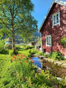 a red brick house with a pond in front of it at Flintegården Kårhus in Borgund