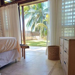 a bedroom with a bed and a large sliding glass door at Casa meravigliosa vicino alla spiaggia con grande piscina e giardino in Beberibe