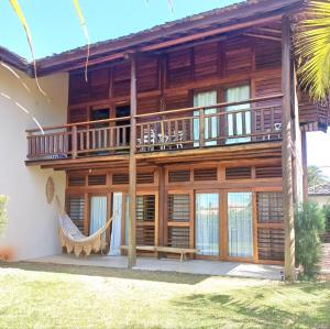 a house with a hammock in front of it at Casa meravigliosa vicino alla spiaggia con grande piscina e giardino in Beberibe