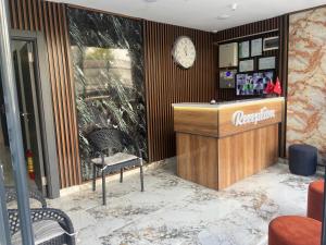 a lobby with a reception desk and a clock on the wall at Güven Suit Otel in Istanbul