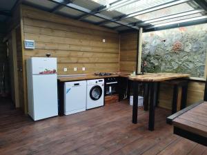 a kitchen with a refrigerator and a washing machine at Location Saisonnière Les Caféiers in Le Tampon +6 photos