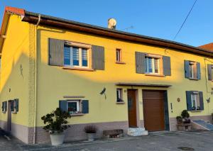 a yellow house with windows and a door at gite de plaisance in Lagarde