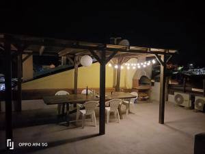 a wooden table and chairs under a pavilion at night at I tre scalini in Stintino