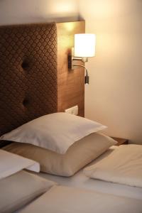 a bedroom with a headboard and a lamp on a bed at Hotel Geisler Tulfes in Tulfes
