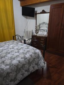 a bedroom with a bed and a dresser and a mirror at Casa India in Assemini +3 photos