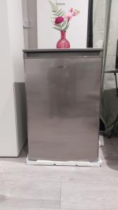 a refrigerator with a vase on top of it at Serene and Cosy Private Studio in Milton Keynes