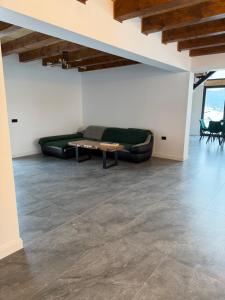 a living room with a green couch and a table at Refugiul din Deal in Mărgău +1 photo