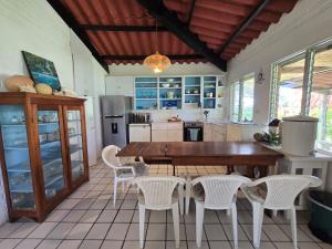 a kitchen with a wooden table and white chairs at DL-Cozy Chalet in Lívingston +20 photos