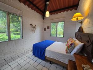 a bedroom with a bed in a room with windows at DL-Cozy Chalet in Lívingston