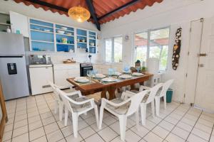 a kitchen with a wooden table and white chairs at DL-Cozy Chalet in Lívingston