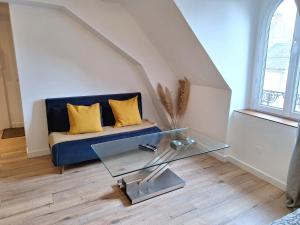 a living room with a couch and a glass table at Faubourg des voyageurs 7 - T2 climatisé 4 personnes - proche axe autoroute et gare in Saran