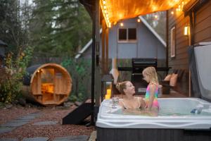 a little girl standing in a bath tub at Rainier Spa Cabin 7 Minutes to Park in Ashford