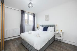 a bedroom with a large white bed and a window at Spacious 2br Gem - Close To Clapham Junction in London