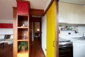 a kitchen with a yellow and red door in a room at Modernist Chalet in Borca di Cadore