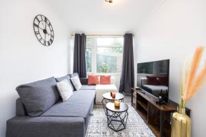 a living room with a couch and a tv at Spacious 2br Gem - Close To Clapham Junction in London