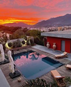 a swimming pool on the roof of a house with a sunset at VILLA ALBA ROSULA in Ajaccio