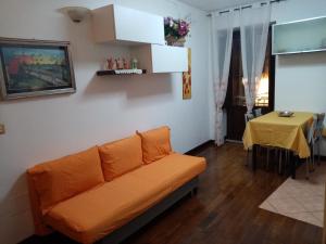 an orange couch in a living room with a table at La Casetta delle Farfalle in Lanciano