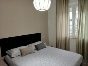 ein Schlafzimmer mit einem großen weißen Bett und einem großen Fenster in der Unterkunft Dimora Cristella in Eboli