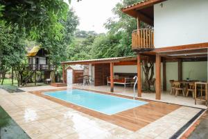 a swimming pool in a backyard with a house at Maria Candida Hospedaria in Areias