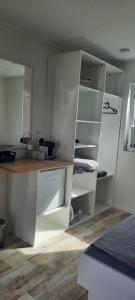 an empty kitchen with white cabinets and a counter at Surf Shack 1 - Zimmer nah am Meer, WLAN, Gemeinschaftsgarten, Surfschule, Naturstrand, Parkplatz, Radfahrweg, Promenade in 10 Minuten erreichbar, Stopover Puttgarden in Dahme