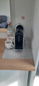 a coffee maker sitting on a shelf in a kitchen at Surf Shack 1 - Zimmer nah am Meer, WLAN, Gemeinschaftsgarten, Surfschule, Naturstrand, Parkplatz, Radfahrweg, Promenade in 10 Minuten erreichbar, Stopover Puttgarden in Dahme
