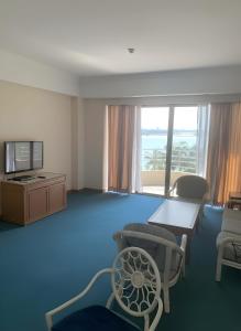 a living room with a blue room with a tv and chairs at 2BR Seaview Condo with Balcony, Riviera Bay Resort Melaka in Malacca