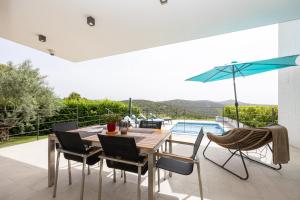 a dining room with a table and chairs and a pool at Villa Olive Tree in Vinišće