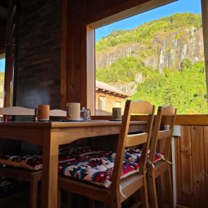 a dining room table with two chairs and a window at Cabaña 2 - Rancho Doble AA in La Junta