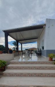 a pavilion with tables and chairs in a building at Villa le Locle in Alicante +4 photos