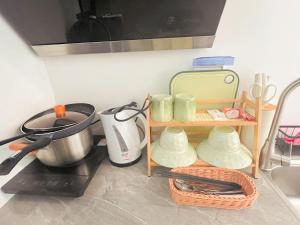 a kitchen with a shelf with cups and a pot at Mmint Resort in Panglao Island