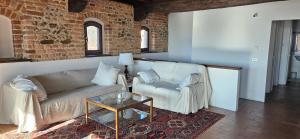 a living room with a couch and a glass table at Al Castello di Valdengo in Valdengo