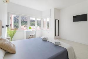 a white bedroom with a large bed and windows at CASA MILA SV19 guesthouse in Alicante