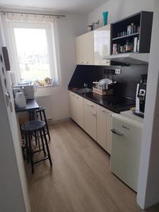 a kitchen with white cabinets and a table and a window at Apartmán Adam in Dolní Moravice