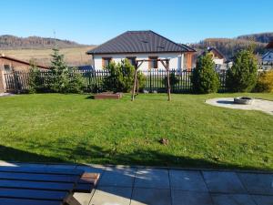 a yard with a fence and a house at Apartmán Adam in Dolní Moravice