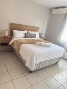 a bedroom with a large bed with two towels on it at Kloppenheim Sectional Lifestyle Complex in Ellisras