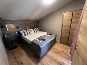 a bedroom with a bed and a wooden floor at Apartment Grey in Mandre