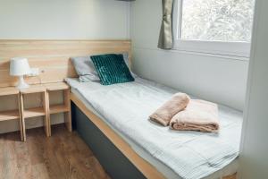 a small bed in a tiny room with a window at House no 4 in Pakoštane
