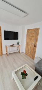 a living room with a couch and a table with flowers on it at Pension am Bach Nice Dreamis in Fuldatal