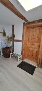 a room with a wooden door and a rug at Pension am Bach Nice Dreamis in Fuldatal