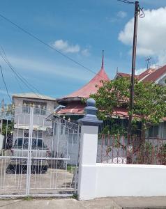 a white fence in front of a house at Gazebo in Port-of-Spain