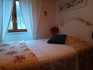 a bedroom with a bed with a floral blanket on it at O Cantinho de Góis in Góis