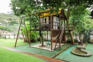 a tree house in a garden with a swing at Maria Candida Hospedaria in Areias
