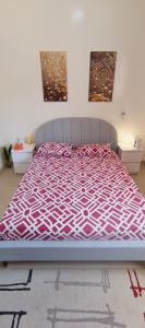 a bedroom with a bed with a purple and white bedspread at bel studio de luxe a thies Sénégal in Thiès