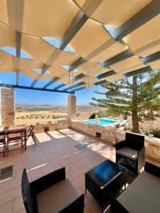 a patio with a table and chairs and a pool at Paros Tranquility Villa in Dhragoulás