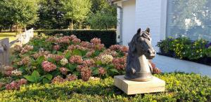 a statue of a horse in front of a garden at Lozerhof Studio in Kruisem