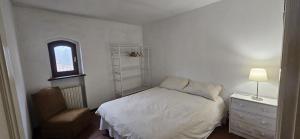 a bedroom with a bed and a chair and a window at Al Castello di Valdengo in Valdengo