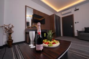 a bottle of wine sitting on a table with a bowl of fruit at Hotel Global Palace in Haskovo