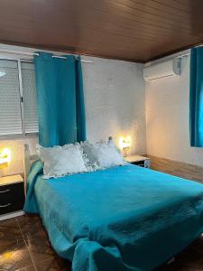 a bedroom with a blue bed with blue curtains at La Dorada in Barra del Chuy +2 photos