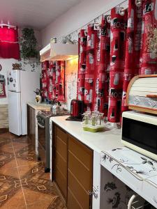 a kitchen with red curtains on the wall at La Dorada in Barra del Chuy