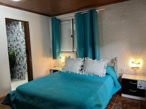 a bedroom with a blue bed with blue curtains at La Dorada in Barra del Chuy